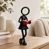 Vrouwelijke Stickyman boekenlezer met rood boek in een warme Scandinavische leeshoek.